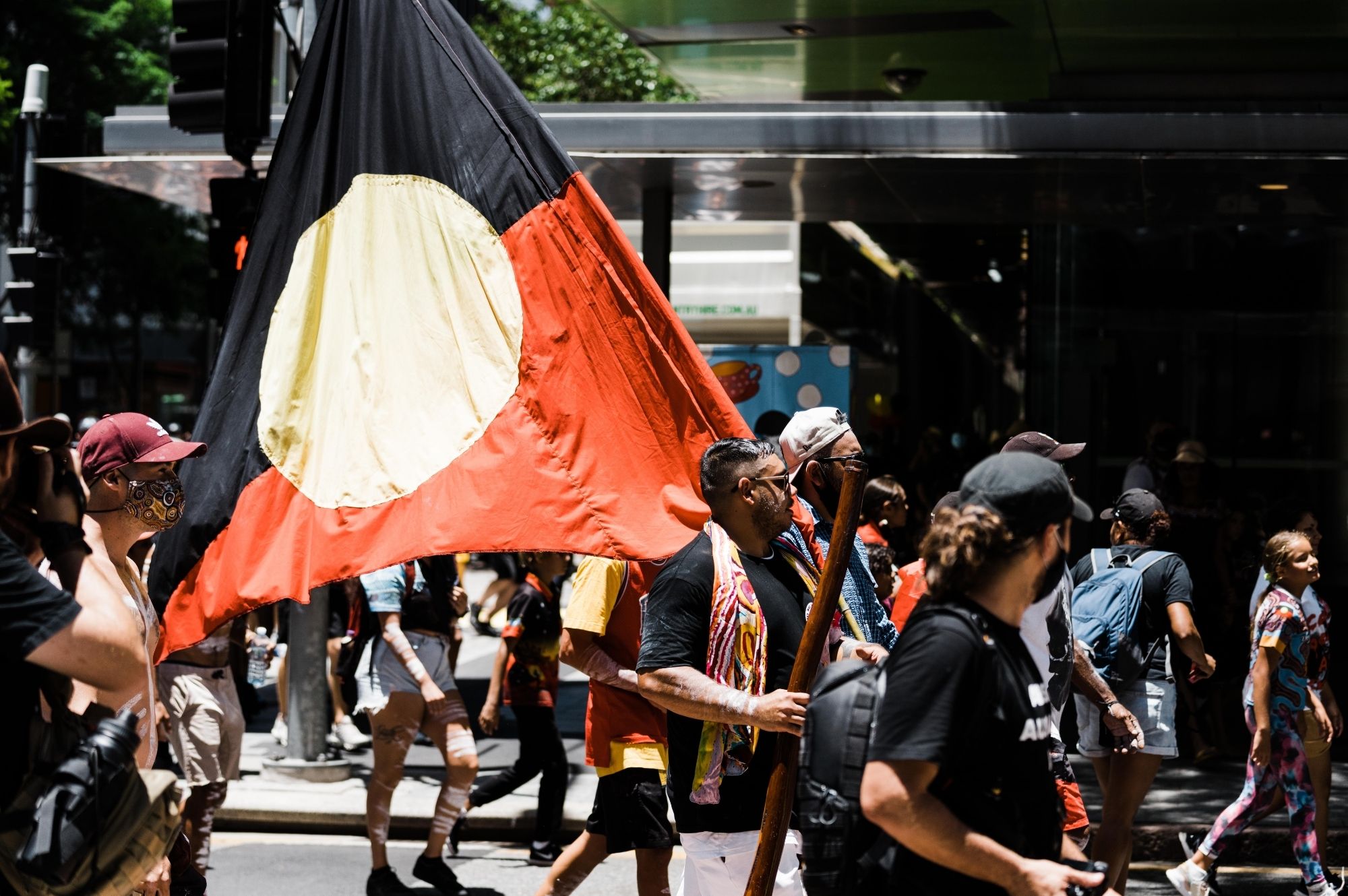 First Nations justice rally with large Aboriginal flag