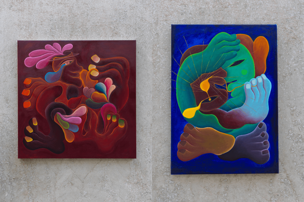 Two of Zoe's abstract colourful painitngs on a concrete wall
